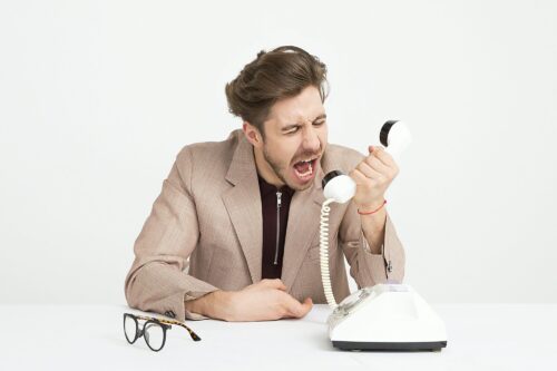 Frustrert mann som roper i telefonen